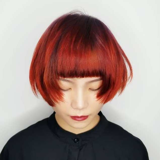 Blunt bangs combined with a vibrant hair color